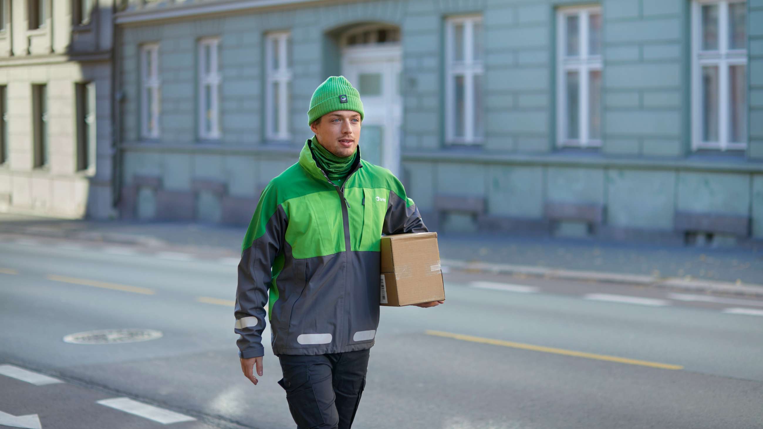 Bringbud går med paket i stadsmiljö