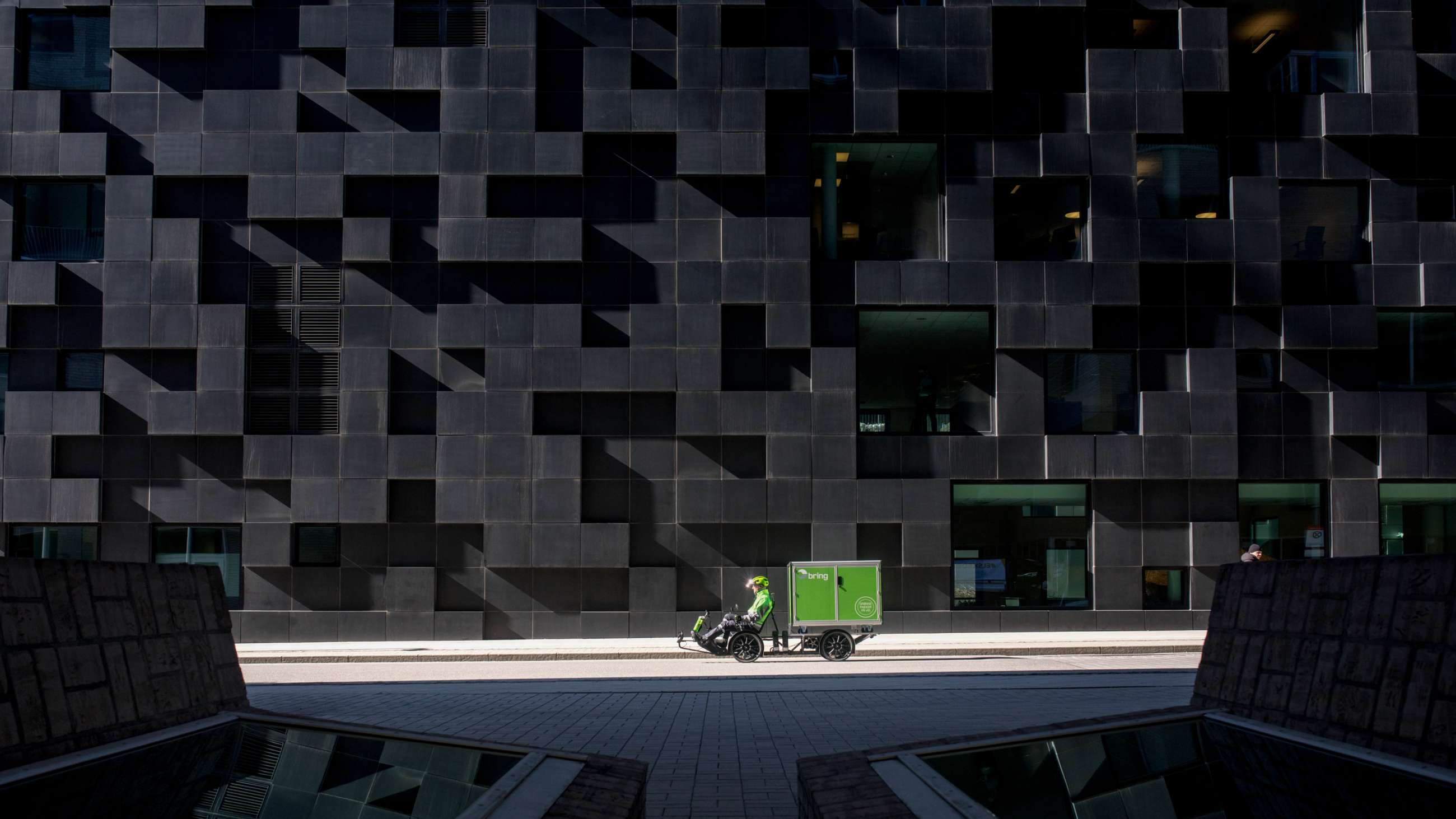 Grön elcykel framför svart vägg