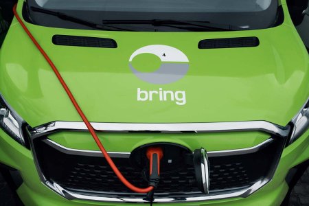 En närbild på en motorhuv på en elektrisk Bringbil som laddas