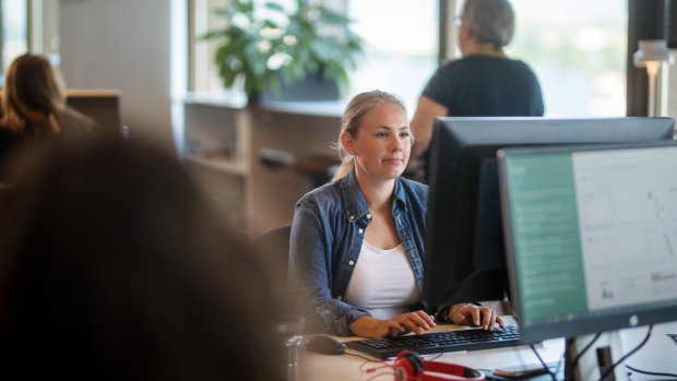 En kvinna sitter framför en dataskärm