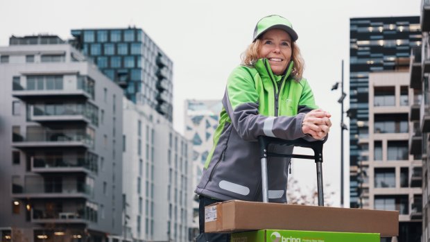 En leednde Bringbud står lutad över en pirra med paket på i stadsmiljö