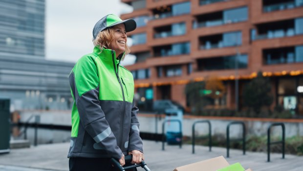 Ett kvinnligt Bringbud drar en pirra med paket på genom staden