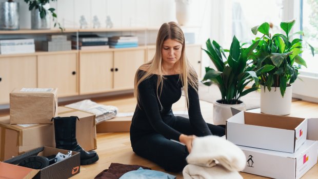 Kvinna som packar kläder i lådor