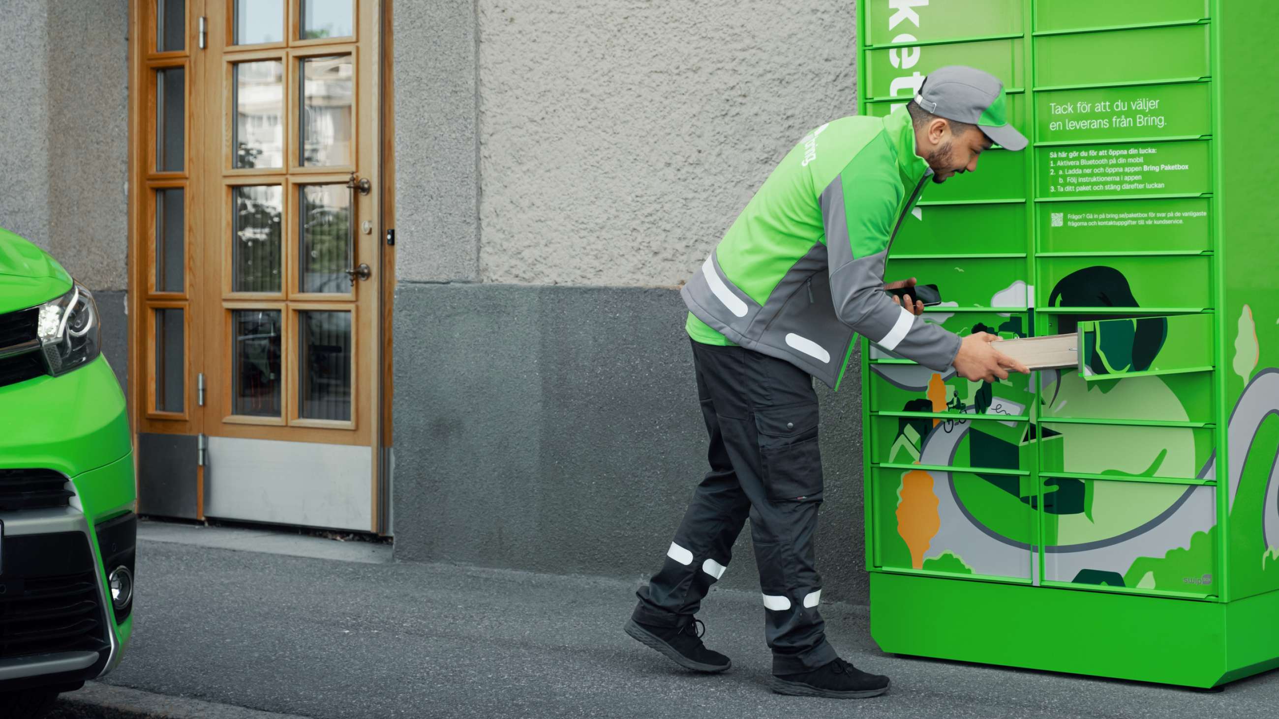 En Bring chaufför står framför en grön Bring paketbox och lämnar paket i en öppen lucka i boxen.