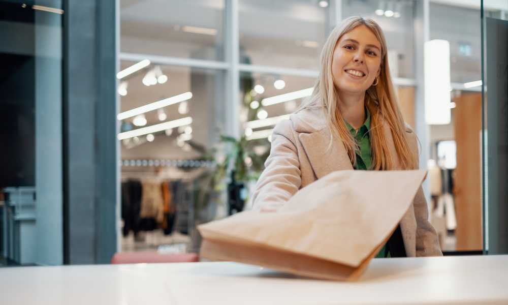 A woman is handing in a parcel for a return.