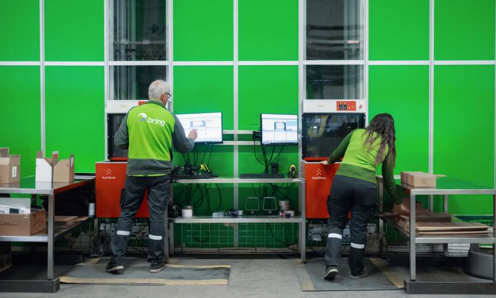 Two Bring employees pack parcels at Autostore