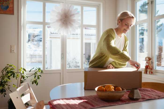Kvinna öppnar paket från nätet