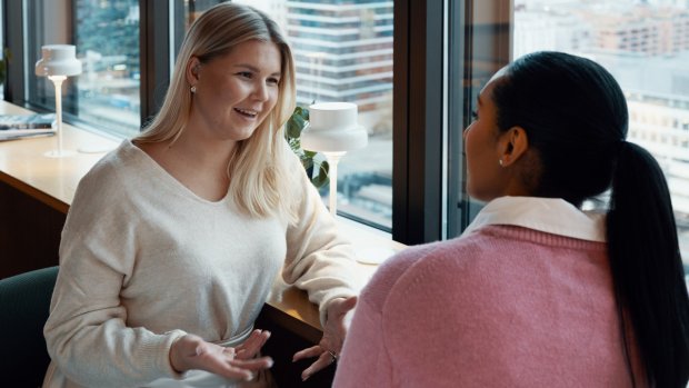 2 kvinnor pratar tillsammans på ett kontor
