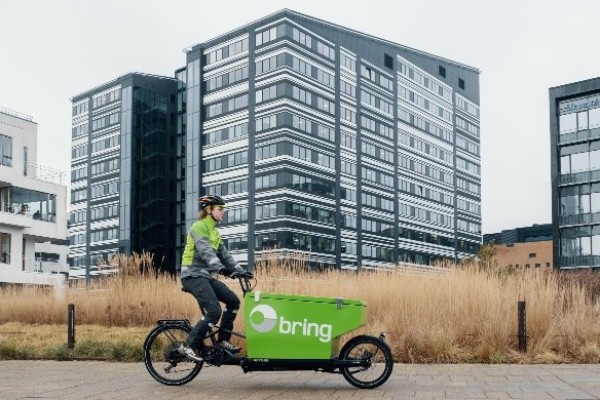 Bring anställd cyklar framför byggnader