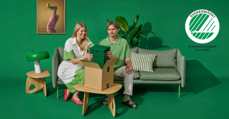 En man och en kvinna sitter på en soffa i ett helgrönt rum. Kvinnan plockar upp ett grönt paket ur en kartong. På bilden finns Svanenloggan.