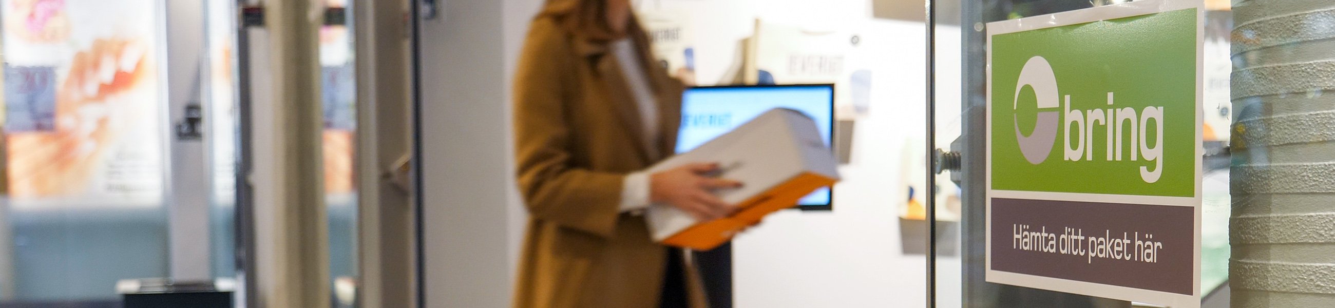 En kvinna med ett paket vid ett Bringombud