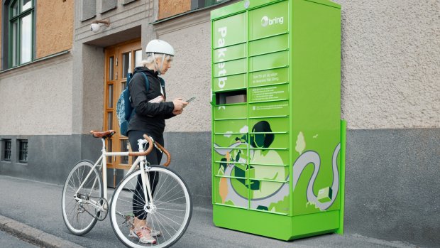 Tjej med cykel vid paketbox