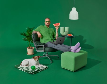 Man sitter bekvämt i en soffa i grön Bring-miljö, med en vattenmelon i handen.