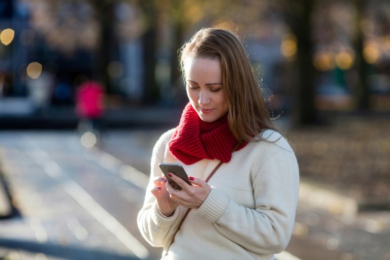 ung-tjej-står-ute-handlar-på-mobilen