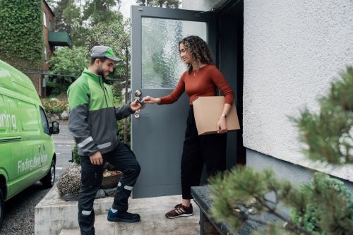 Kvinna tar emot paket av en Bringchaufför.