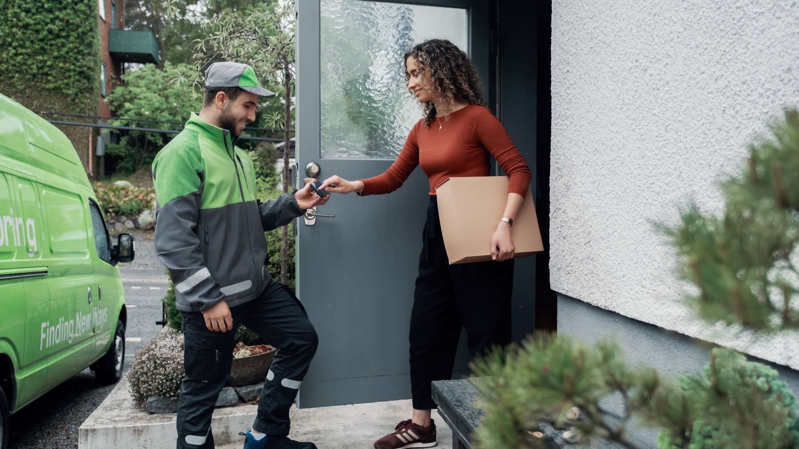 Kvinna tar emot paket av en Bringchaufför.