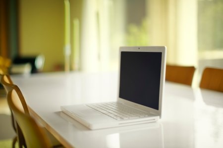En laptop står själv på ett bord