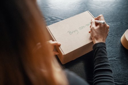 En kvinna skriver en paketbod på ett paket
