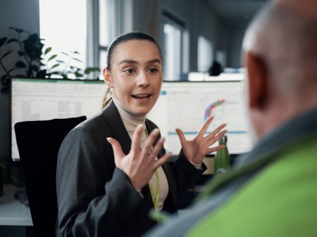 En kvinnlig Bring medarbetare sitter i dialog med en annan kollega mittemot henne