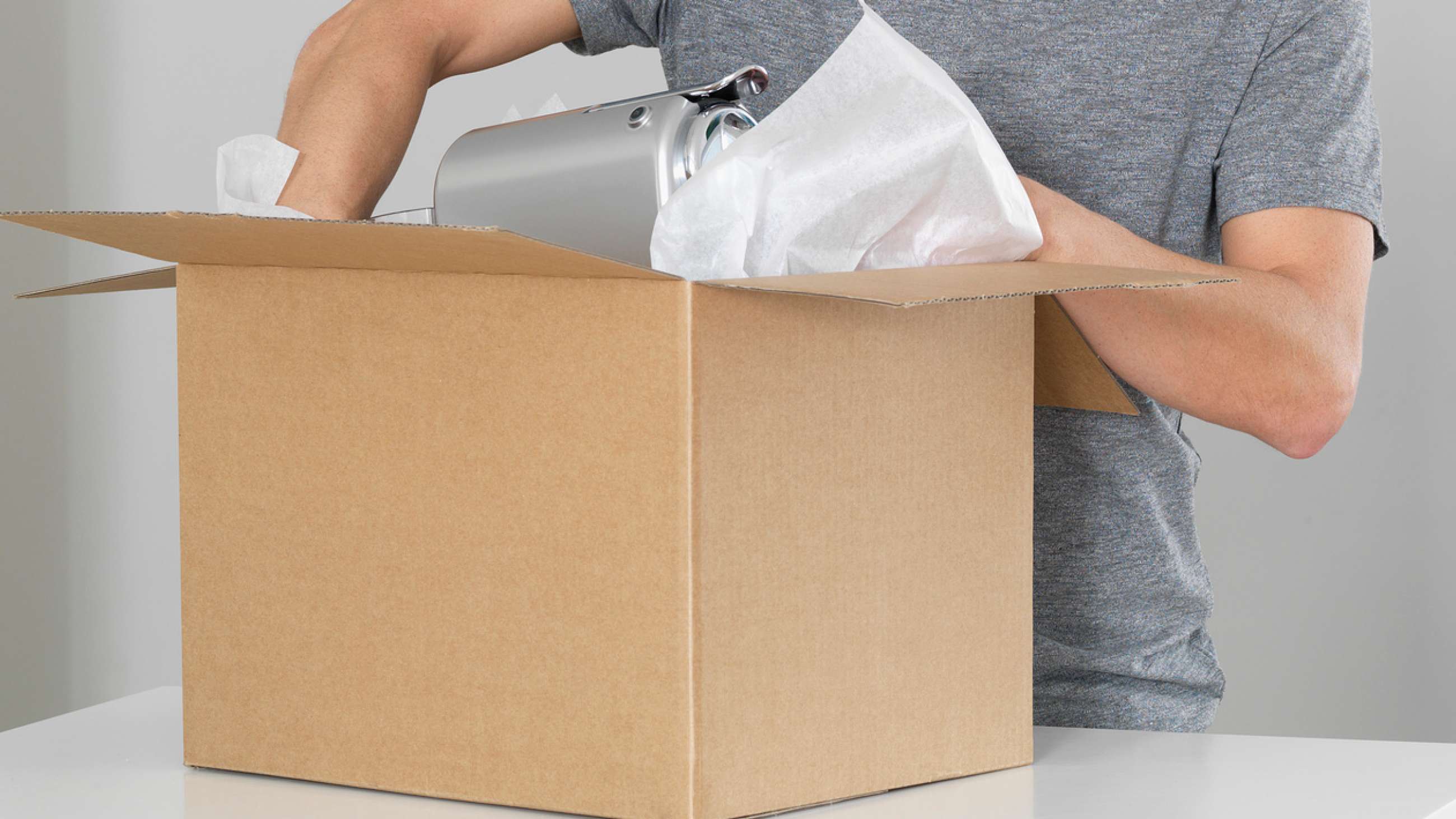 En man packar något ömtåligt i ett paket
