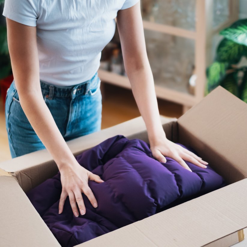 En kvinna packar ner en vara i en låda