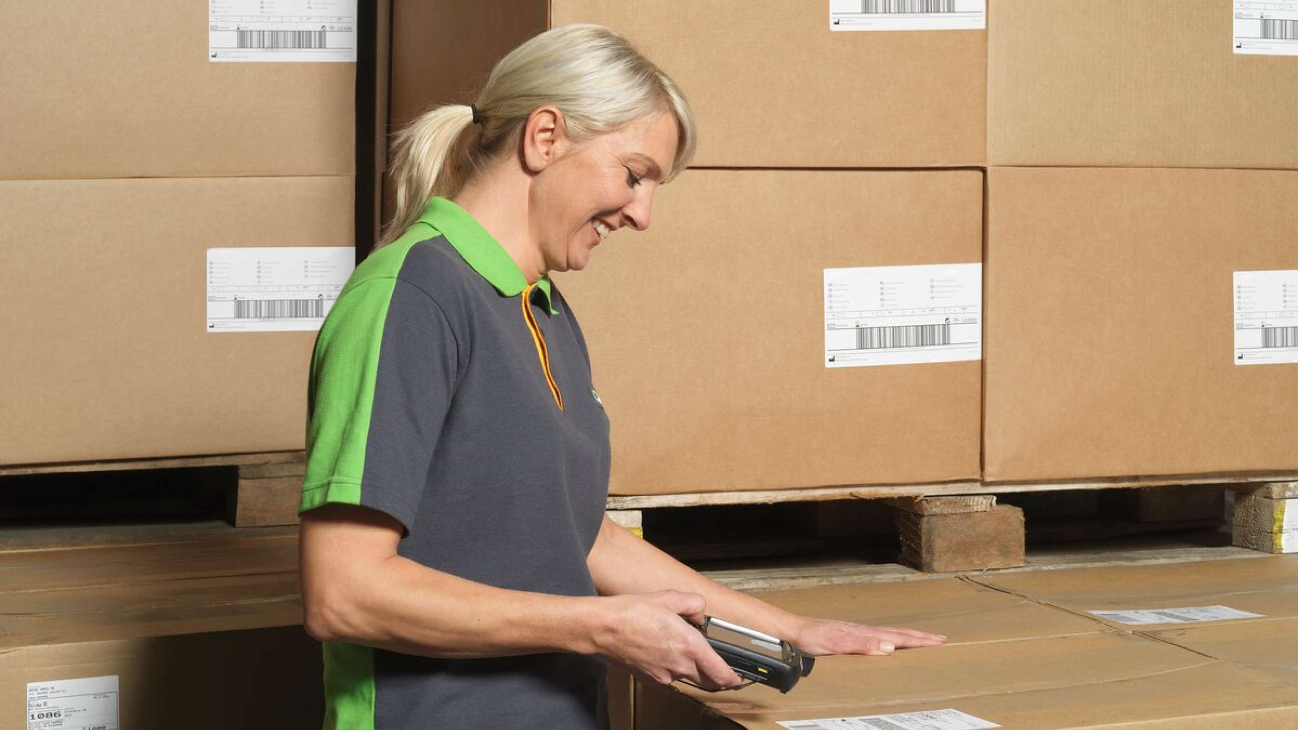 En leende kvinna scannar etiketten på ett paket