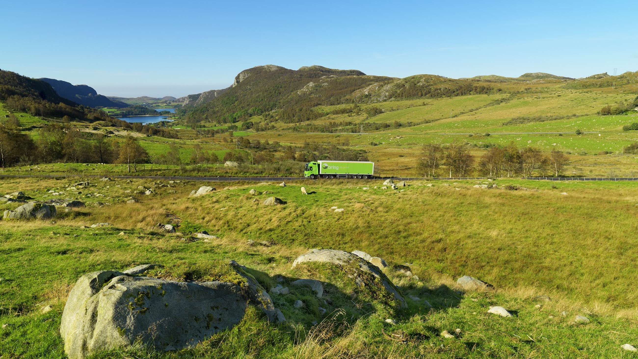 En Bring-lastbil kör i ett vackert landskap med mycket grönska