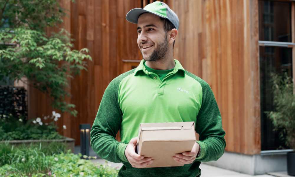 Ett Bringbud står och håller i ett paket framför sig.