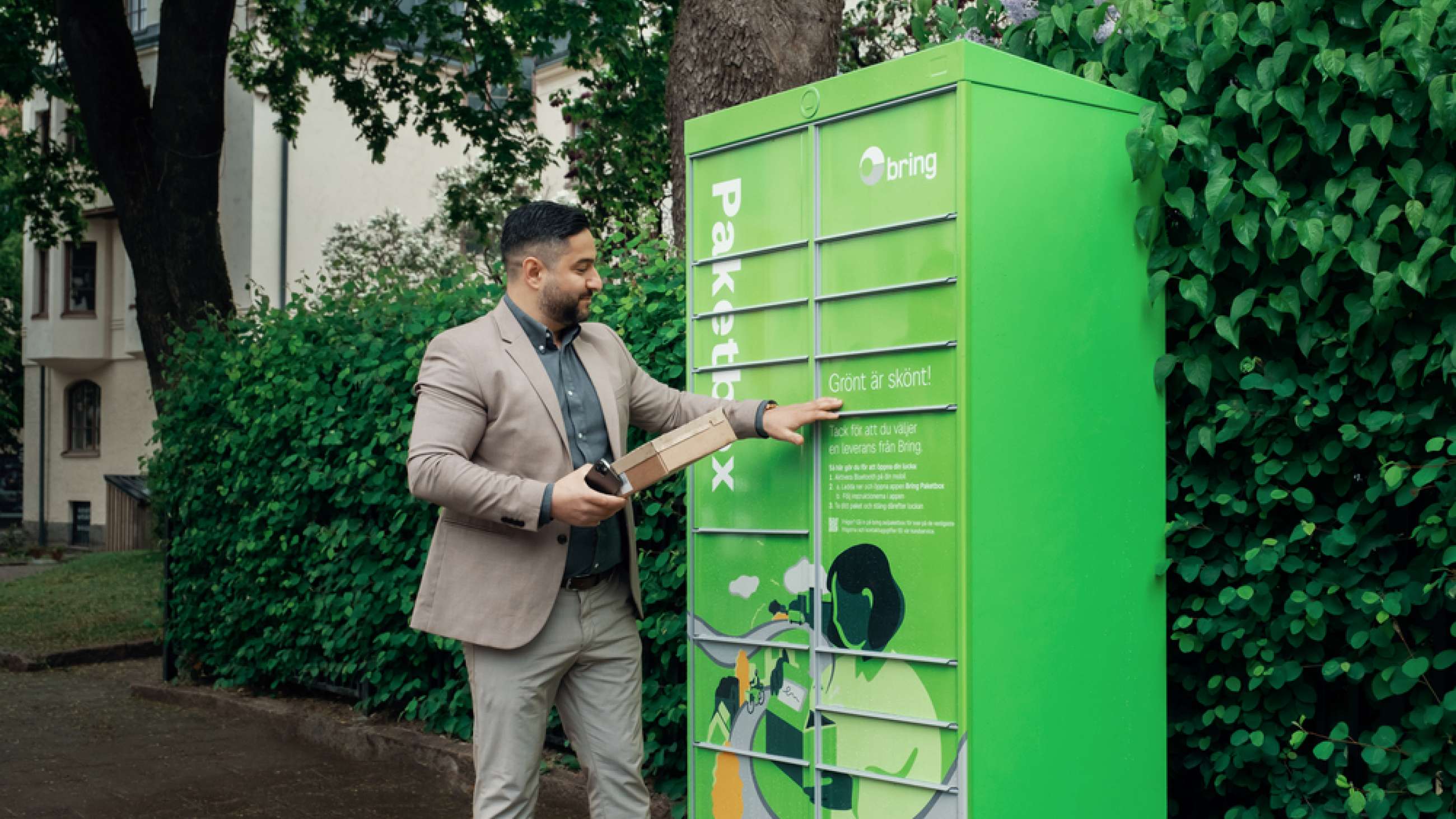 En man hämtar paket från en Bring paketbox